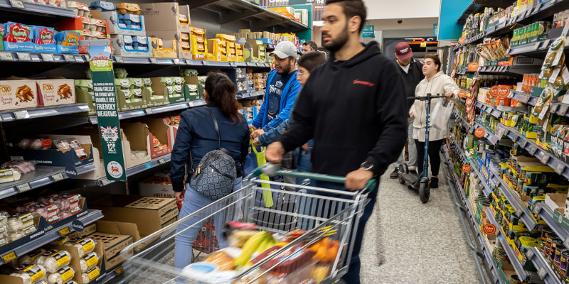 Student in supermarket pushing trolley