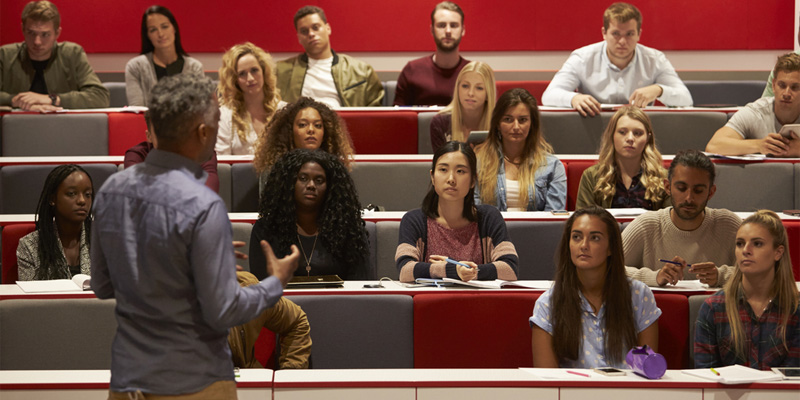 University lecture hall with lecturer at front teaching students