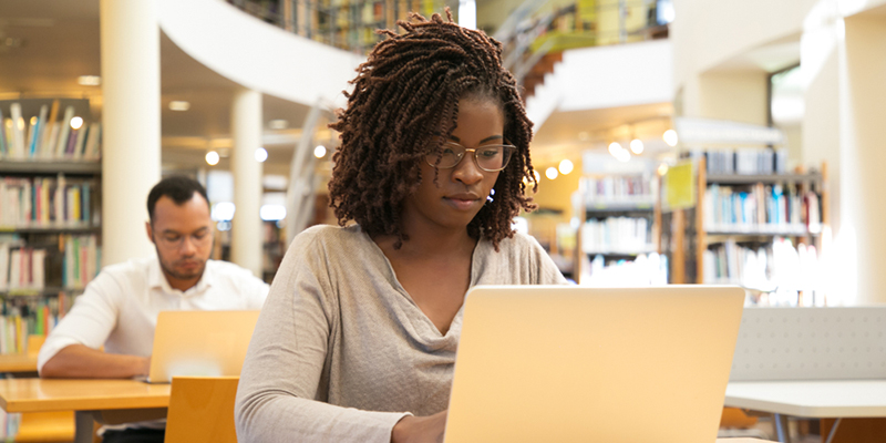 Woman using a laptop in the library