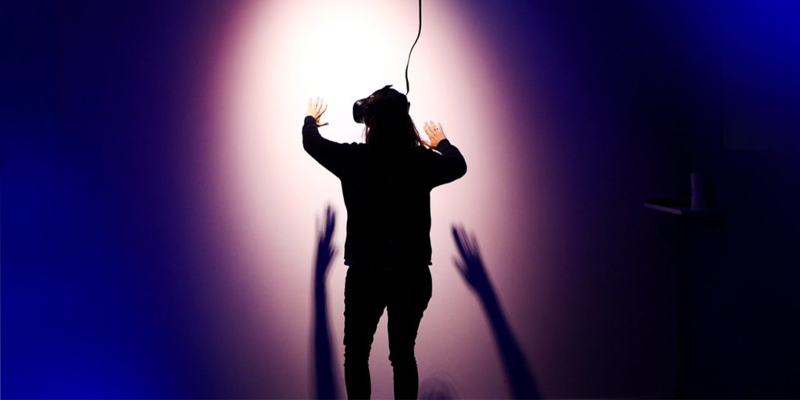 Student wearing a virtual reality headset, with a spotlight on them