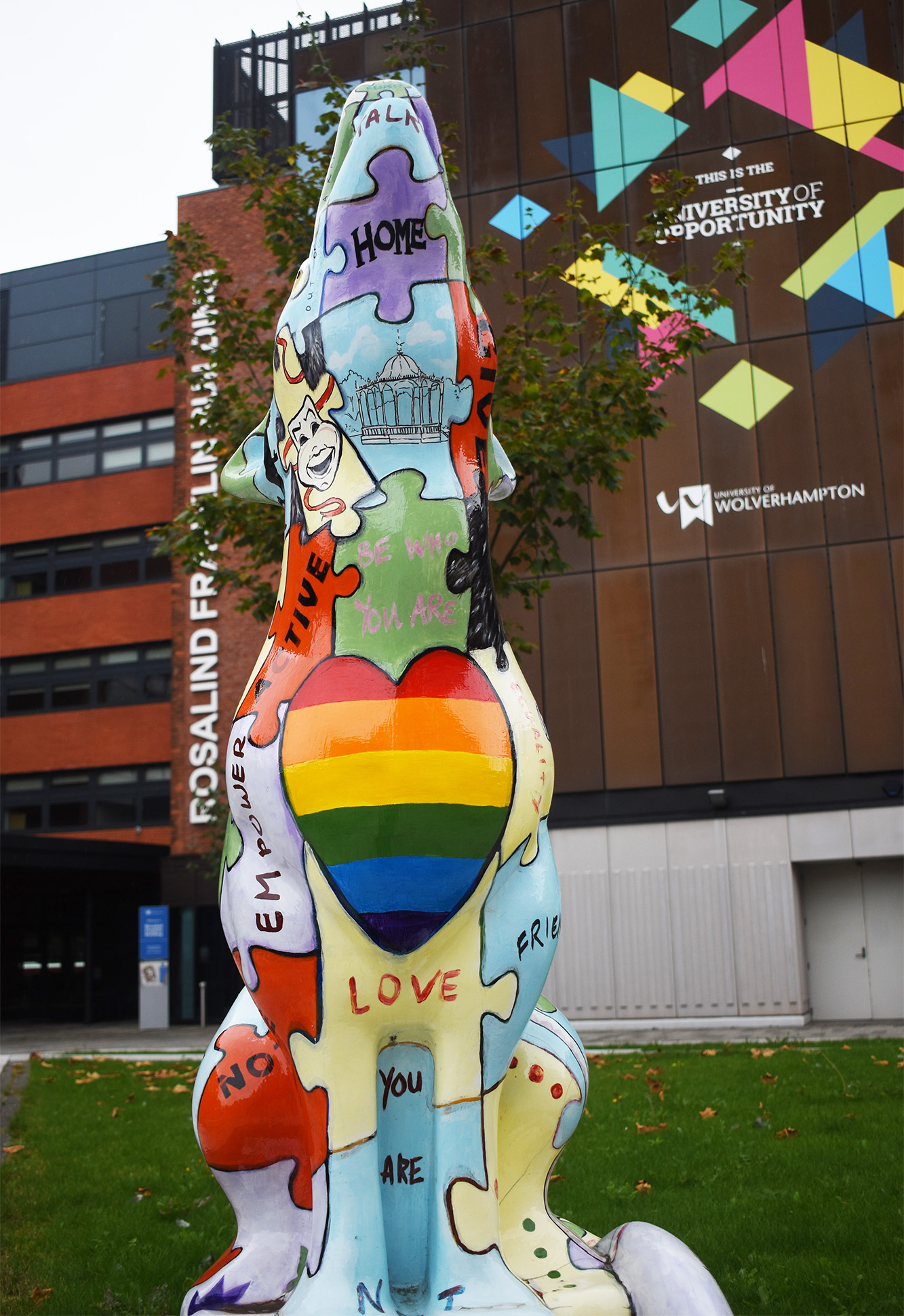 Statue of wolf with painted messages of wellbeing outside Wolverhampton University