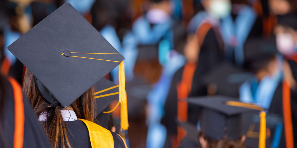 Back of university graduate's head, wearing mortar board cap at graduation ceremony