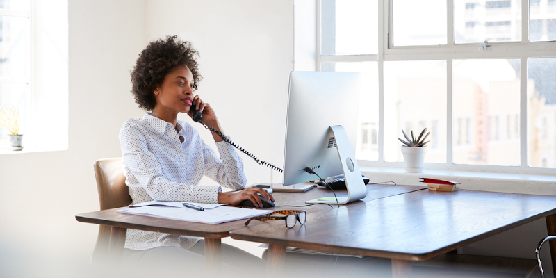 Business woman on phone and using computer