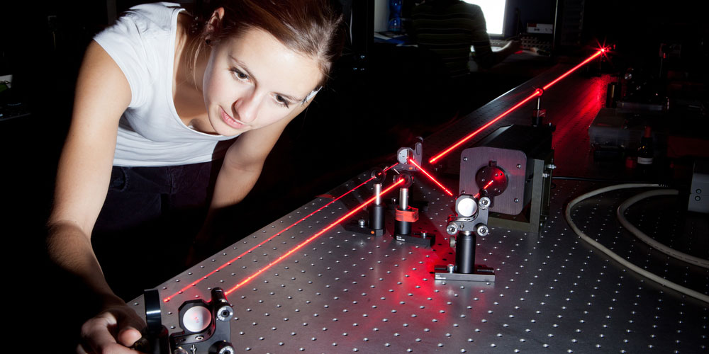 Scientist aligning laser beam in laboratory