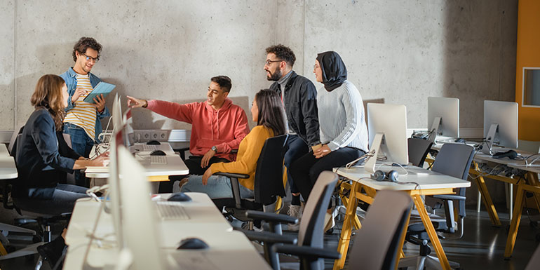 Stock image of a group of students working together in a computer lab.