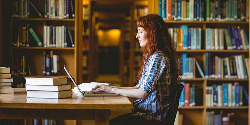 Student in library with laptop