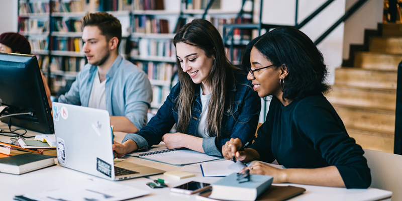 Three students working in the library