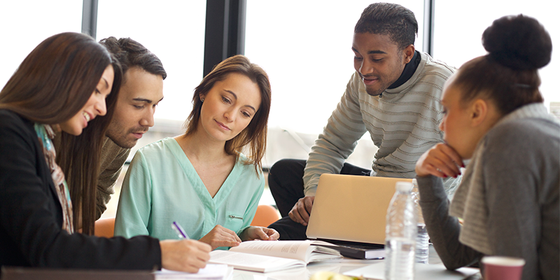 Students sat around a table discussing work