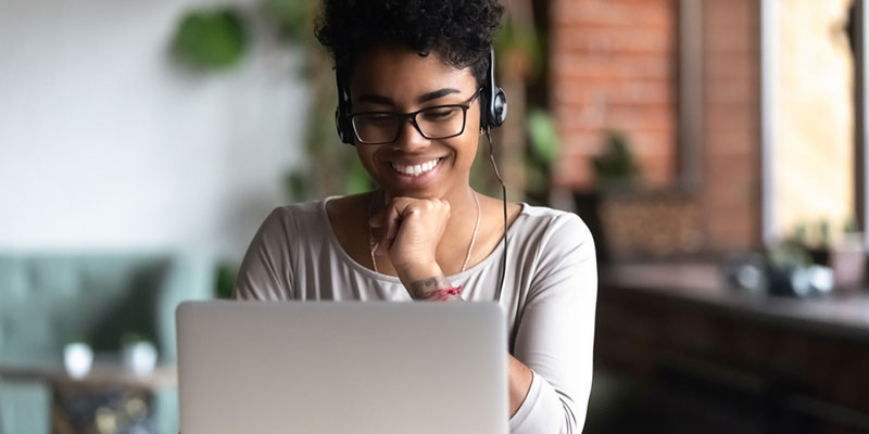 Student sitting at a laptop with headphones on