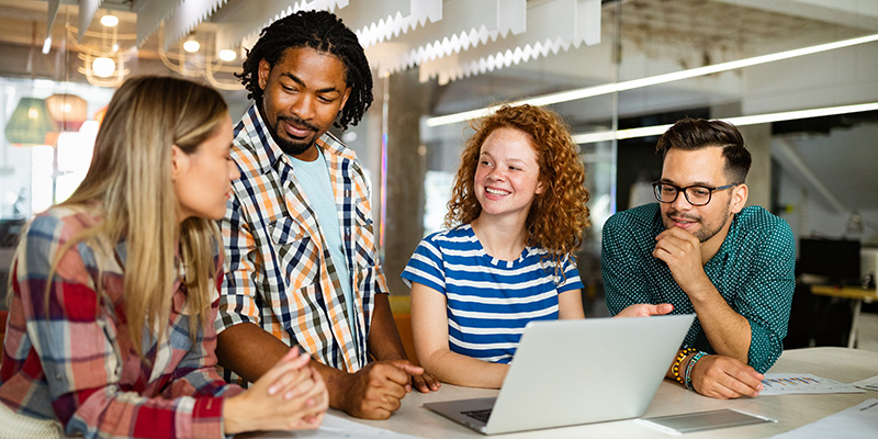 Four students looking at a laptop