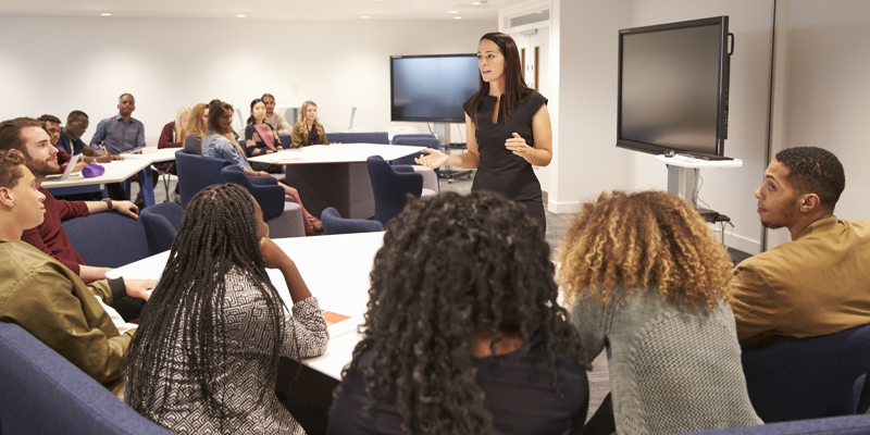 Diverse students in lecture theatre with female lecturer